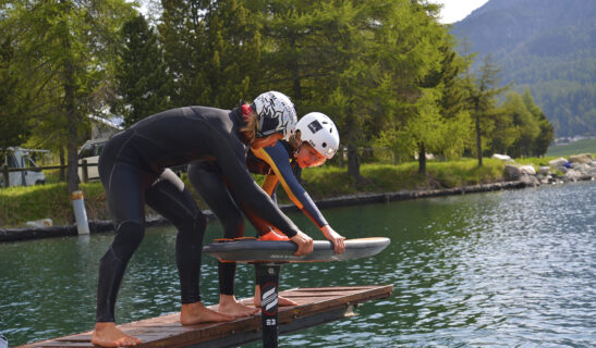 two people about to be pump foiling on a lake