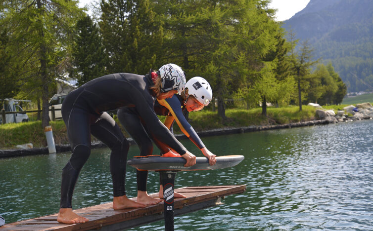 two people about to be pump foiling on a lake