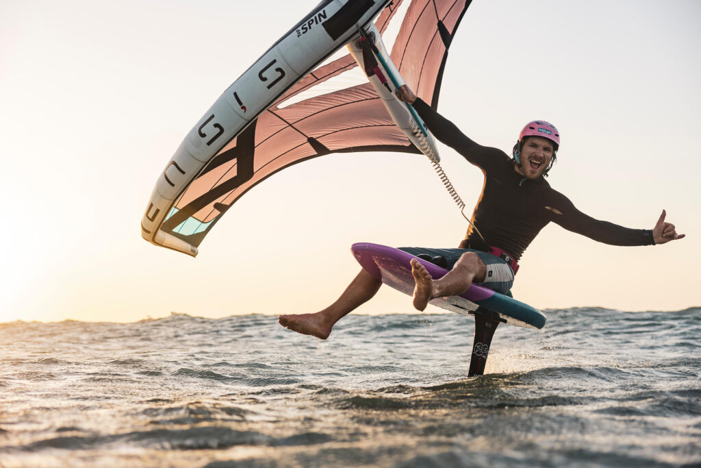 man chilling on a board with a wing in his hand